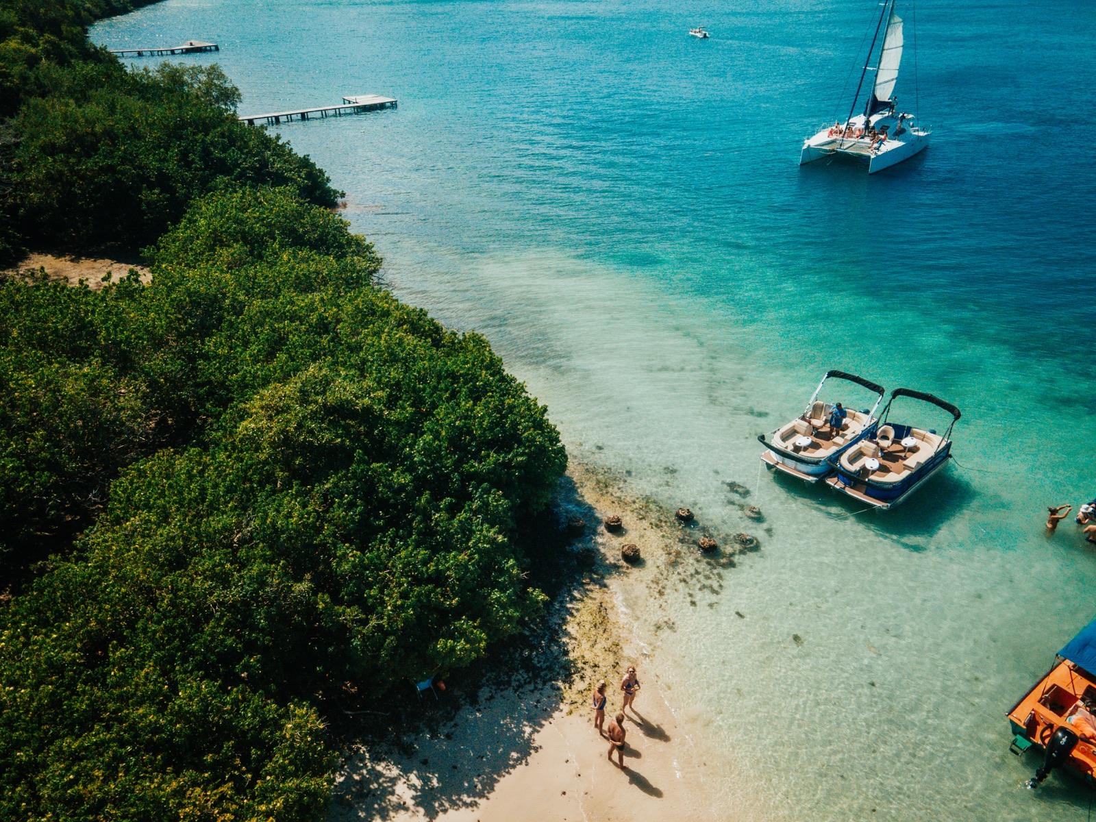 Deux pontoon boats Lounge Cruise mouillés dans une baie des Caraïbes, vus du ciel